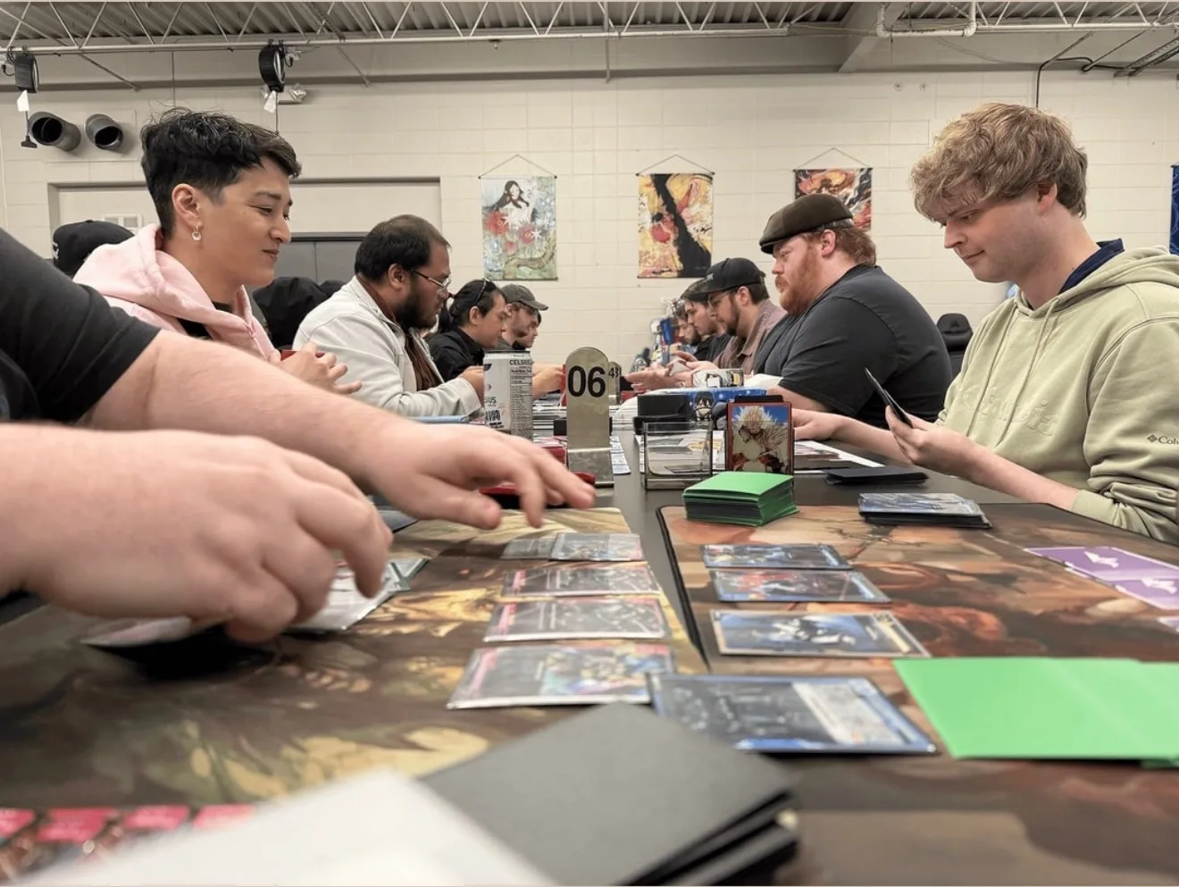 Players trade and play cards together across a table at Izzi's Gym