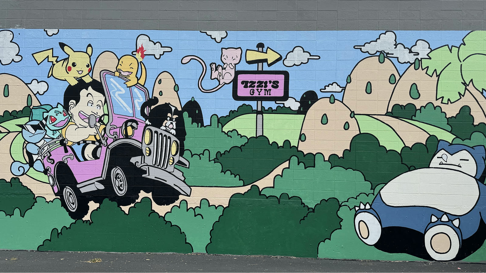 The colorful Izzi's Gym wall mural, with the store sign at the center of a playful character-filled landscape
